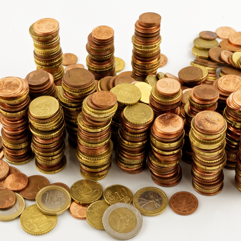 Много блестящих  монет евро на белом фоне