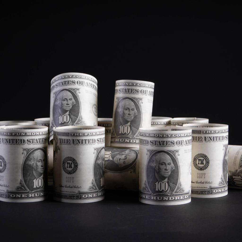 Банкноты сто долларов скручены в трубочки 