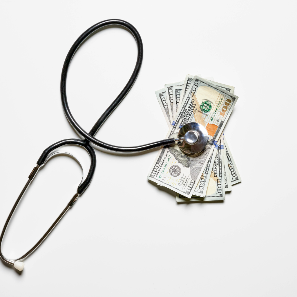 Фонендоскоп с долларами на белом фоне