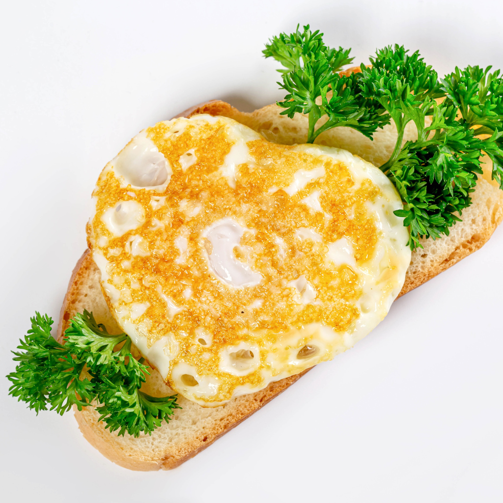 Кусок хлеба с яичницей и петрушкой