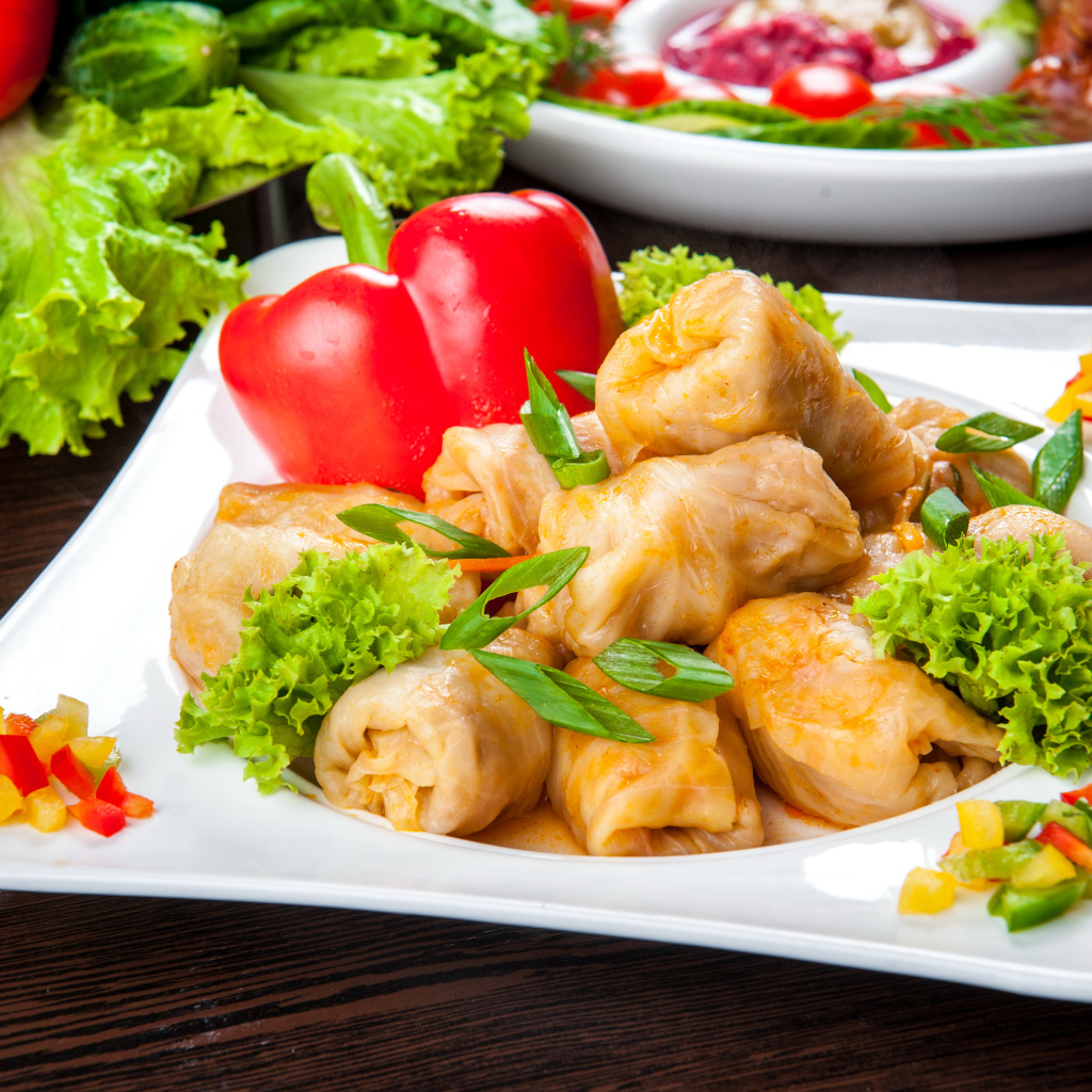 Аппетитные голубцы на тарелке с перцем 