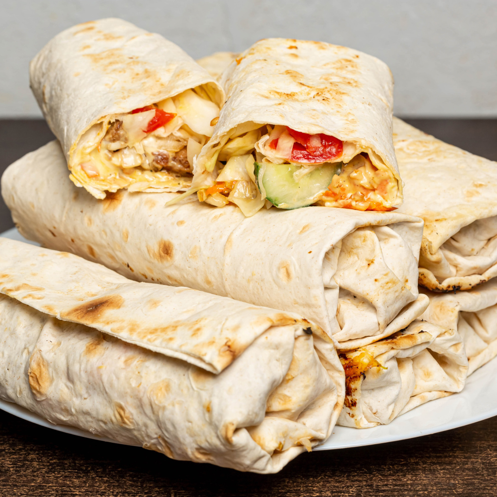 Аппетитная шаурма в лаваше на столе 