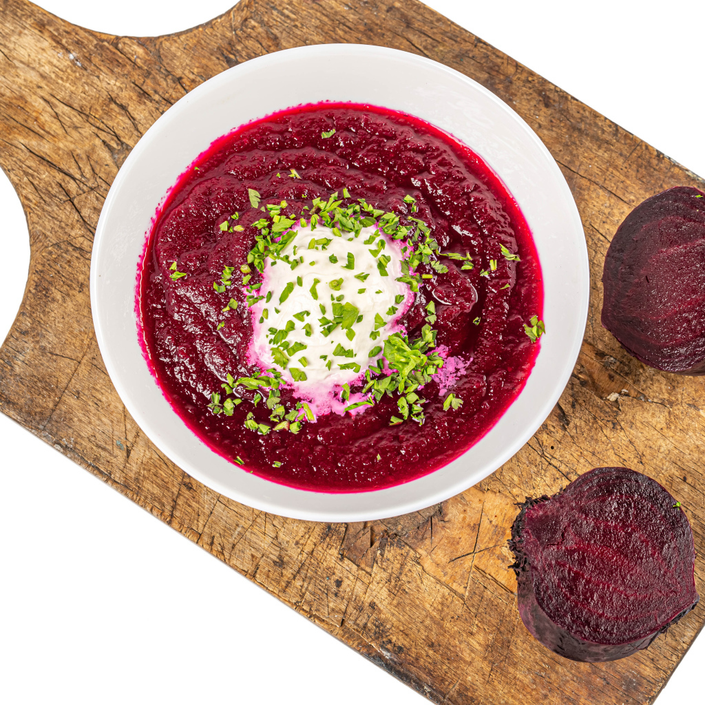 Свекольный суп в тарелке на белом фоне