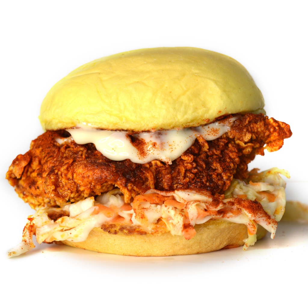 Большой куриный бургер с соусом на белом фоне