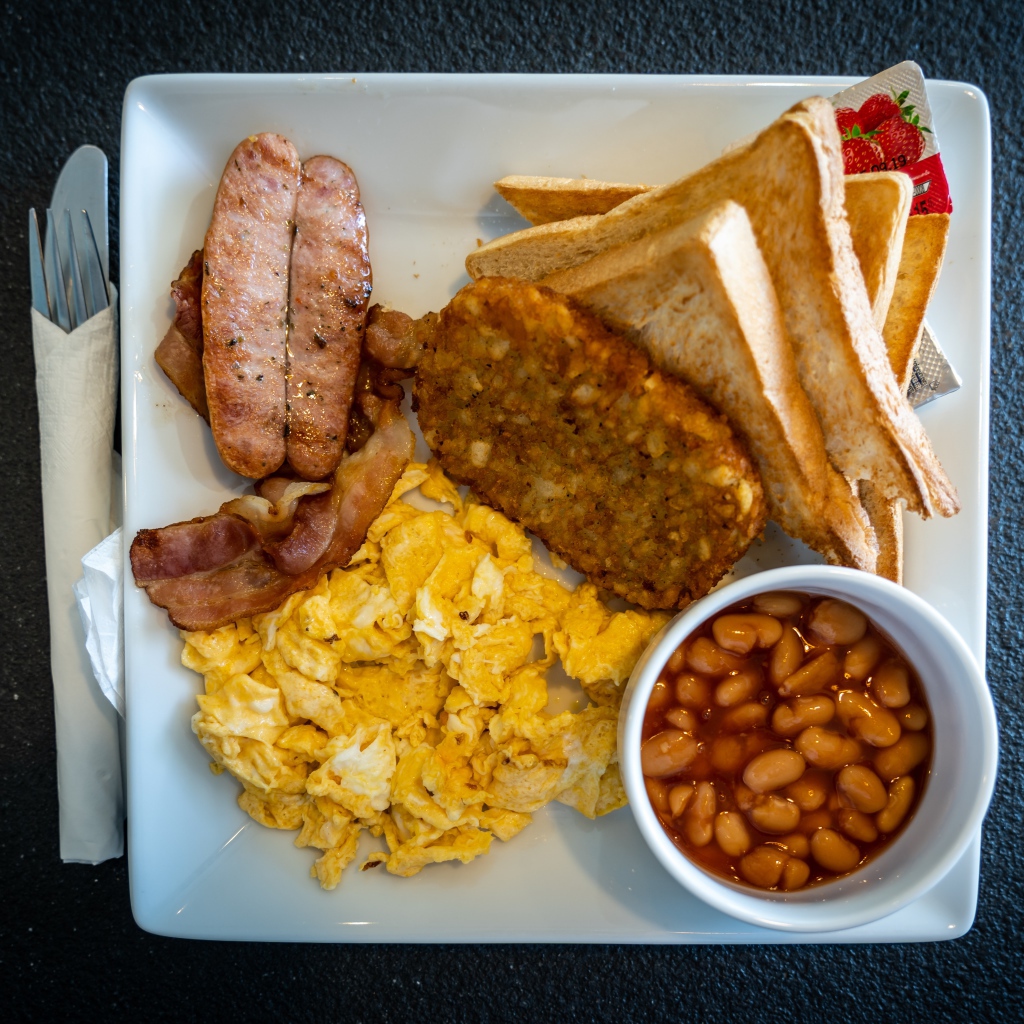 Завтрак на белой тарелке на черном столе 