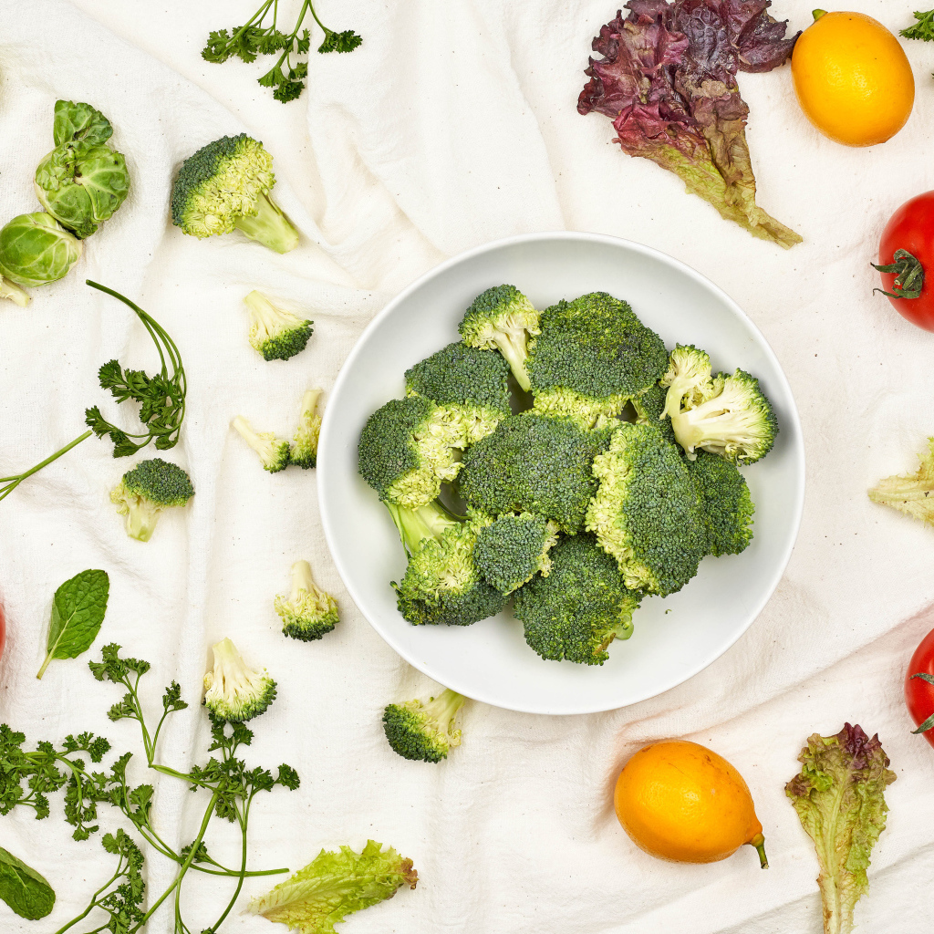 Брокколи на столе с помидорами и зеленью