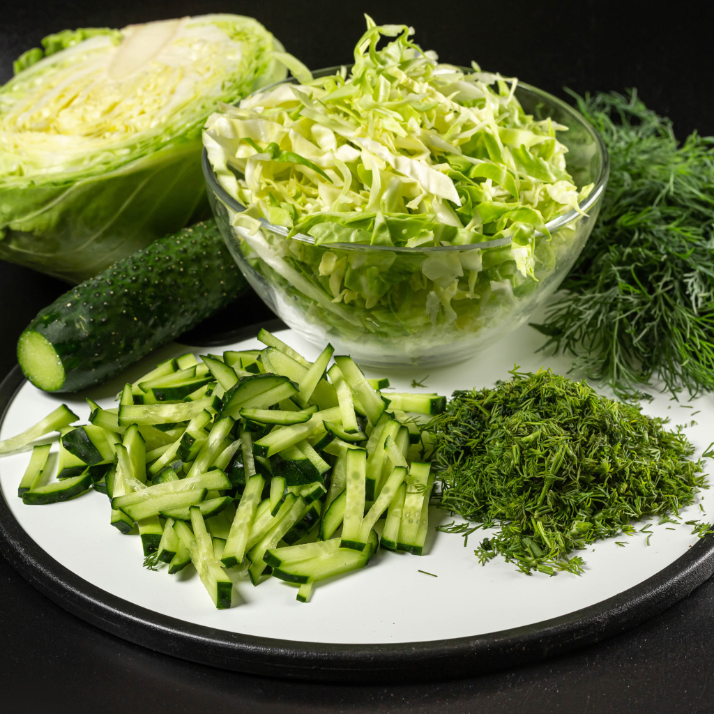 Салат с капусты на столе с огурцами и укропом 