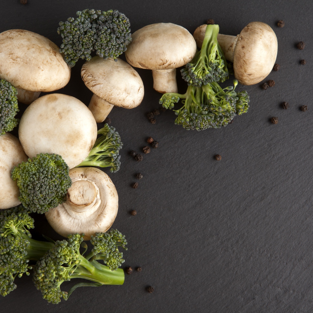 Шампиньоны с брокколи на сером столе 