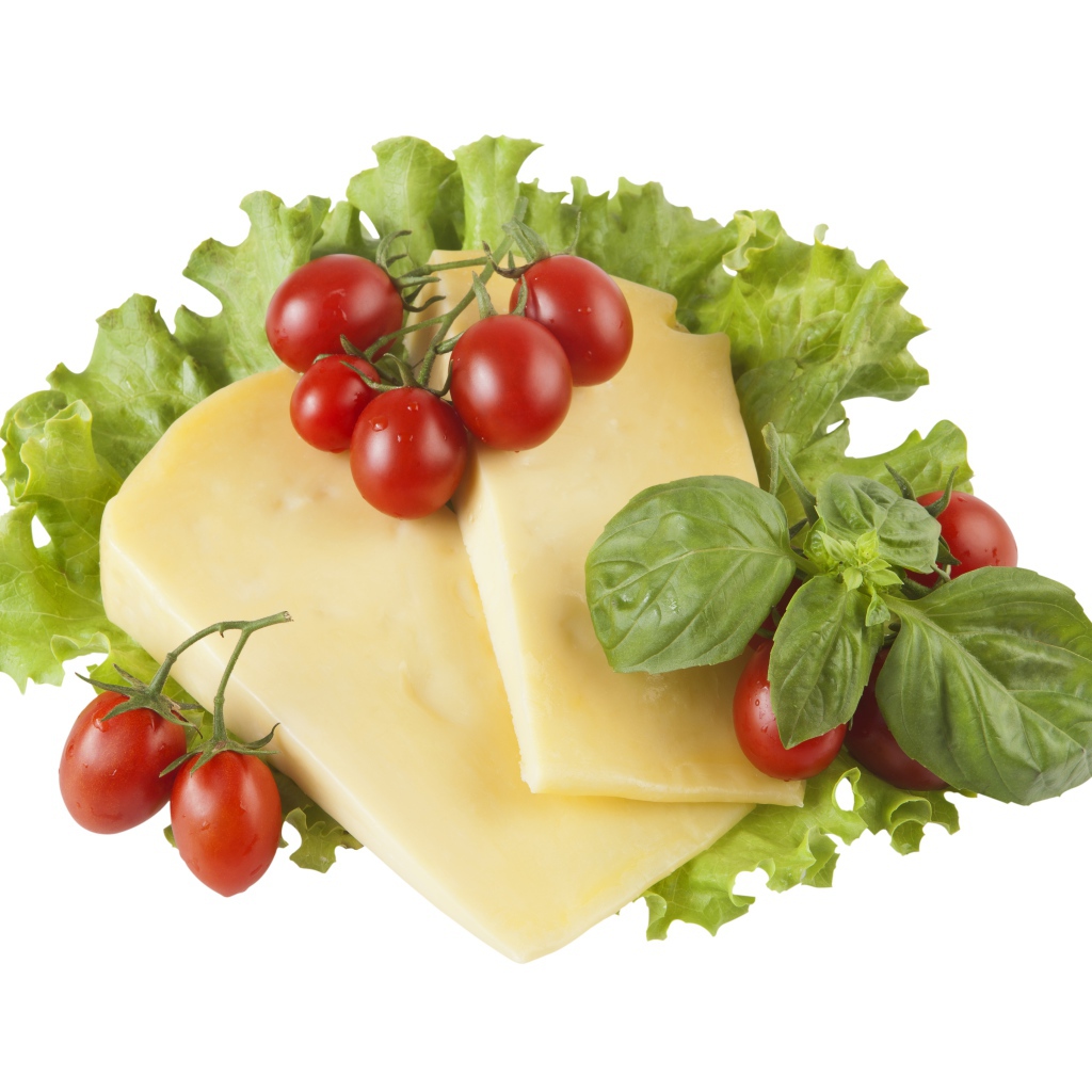 Сыр с помидорами, листьями салата и базиликом на белом фоне