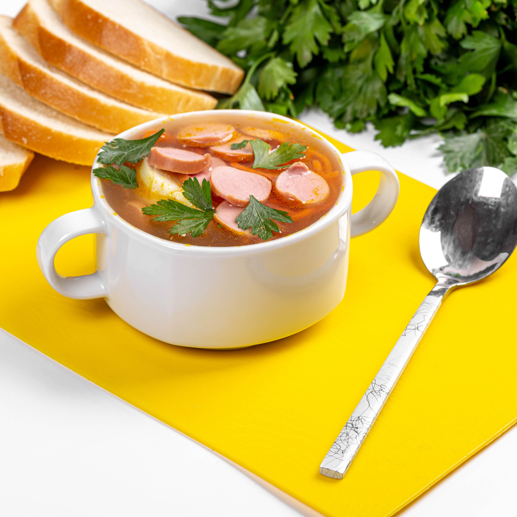Вкусный суп солянка на столе с хлебом и петрушкой