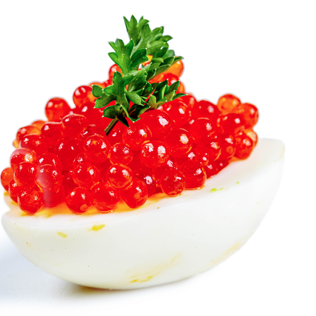Яйцо фаршированное красной икрой на белом фоне