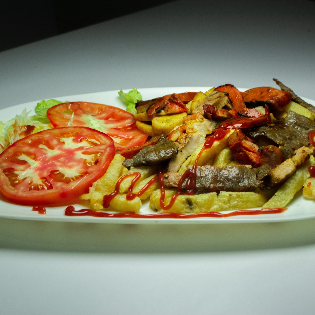 Картофель фри на тарелке с помидорами 