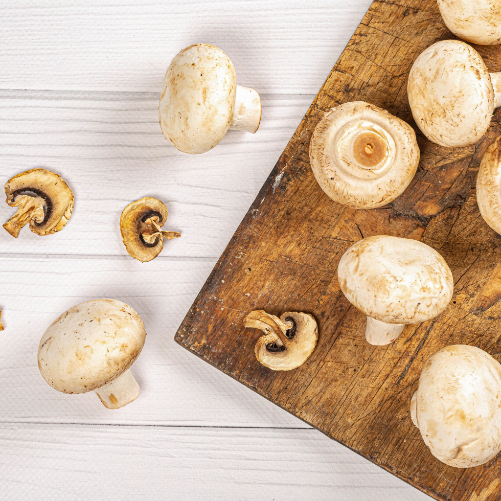 Свежие шампиньоны на разделочной доске
