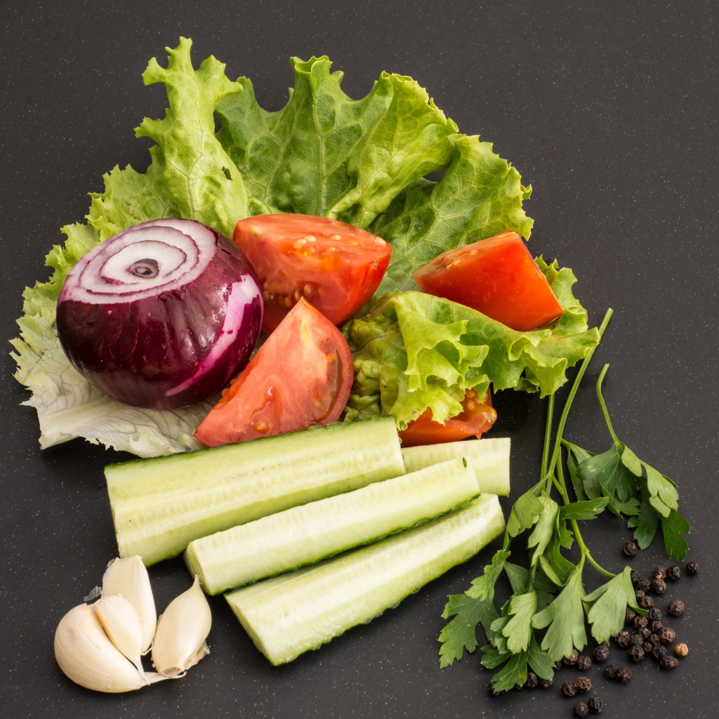Свежие помидоры, огурцы, лук и листья салата 