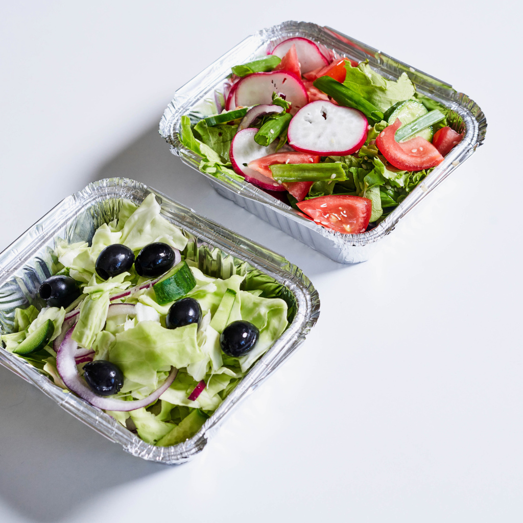 Салат из свежих овощей в тарелках на сером фоне 