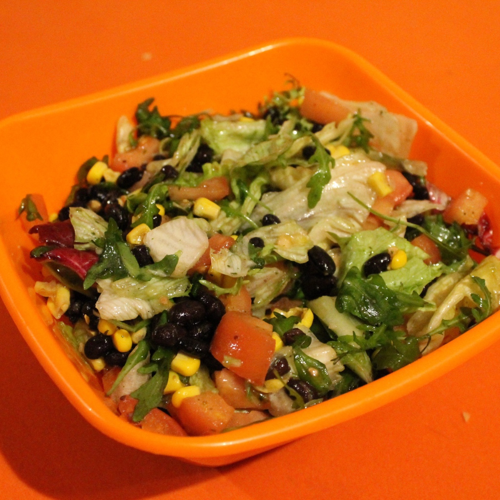 Салат из свежих овощей на оранжевом фоне