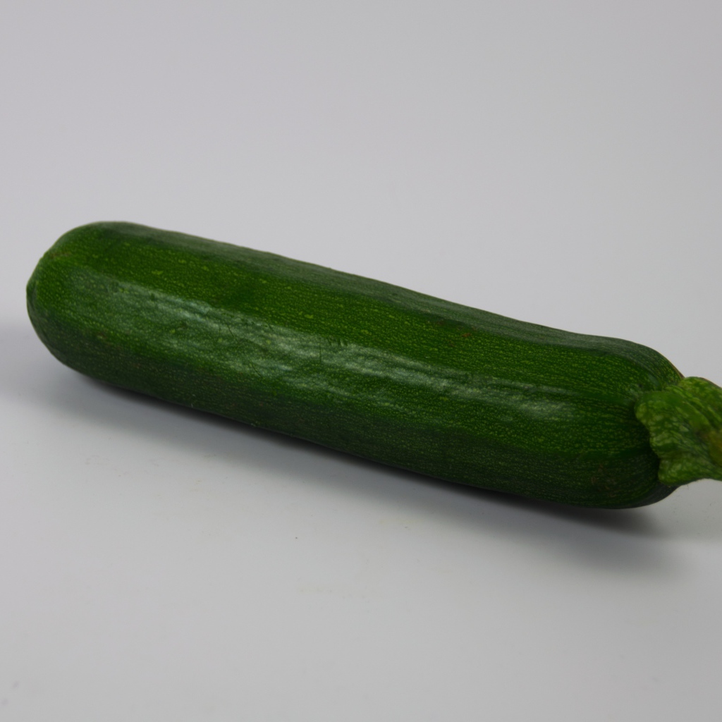 Зеленый кабачок на сером фоне