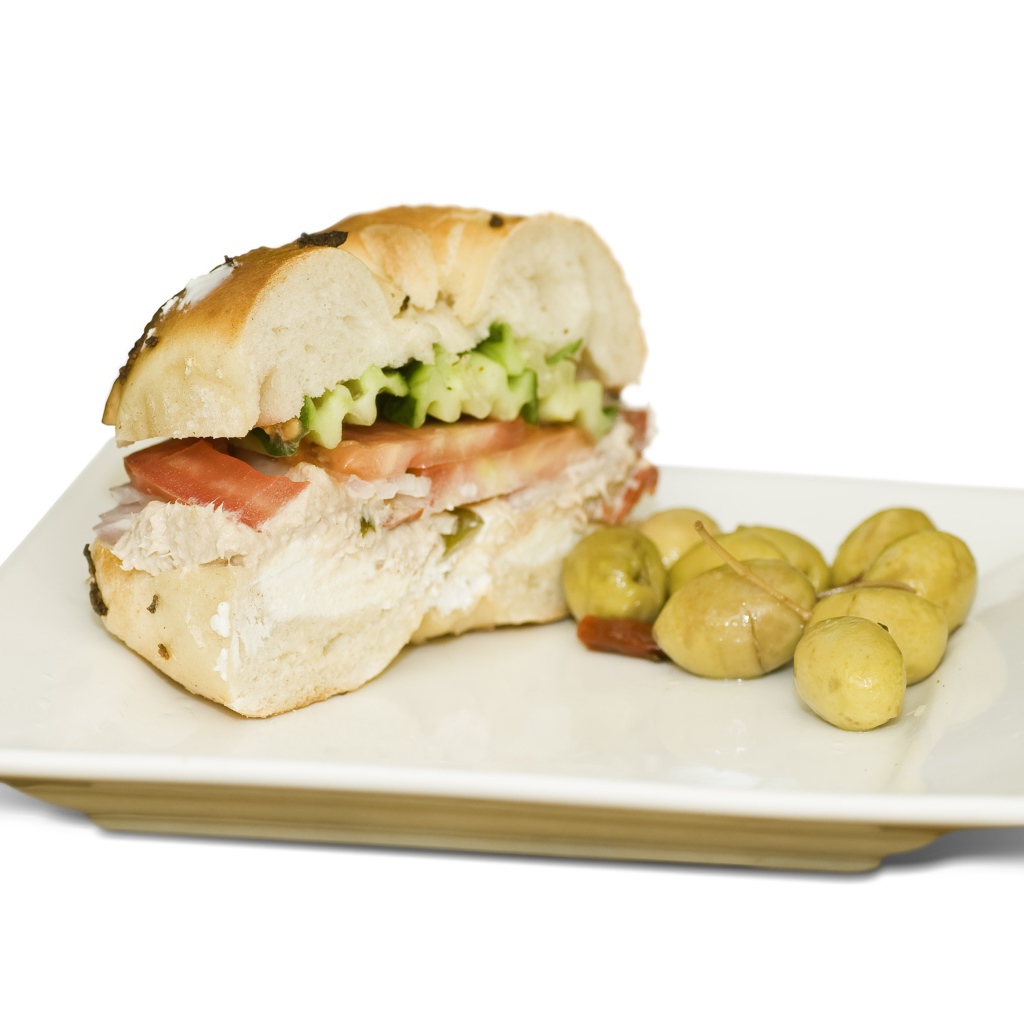 Половина гамбургера на тарелке с оливками