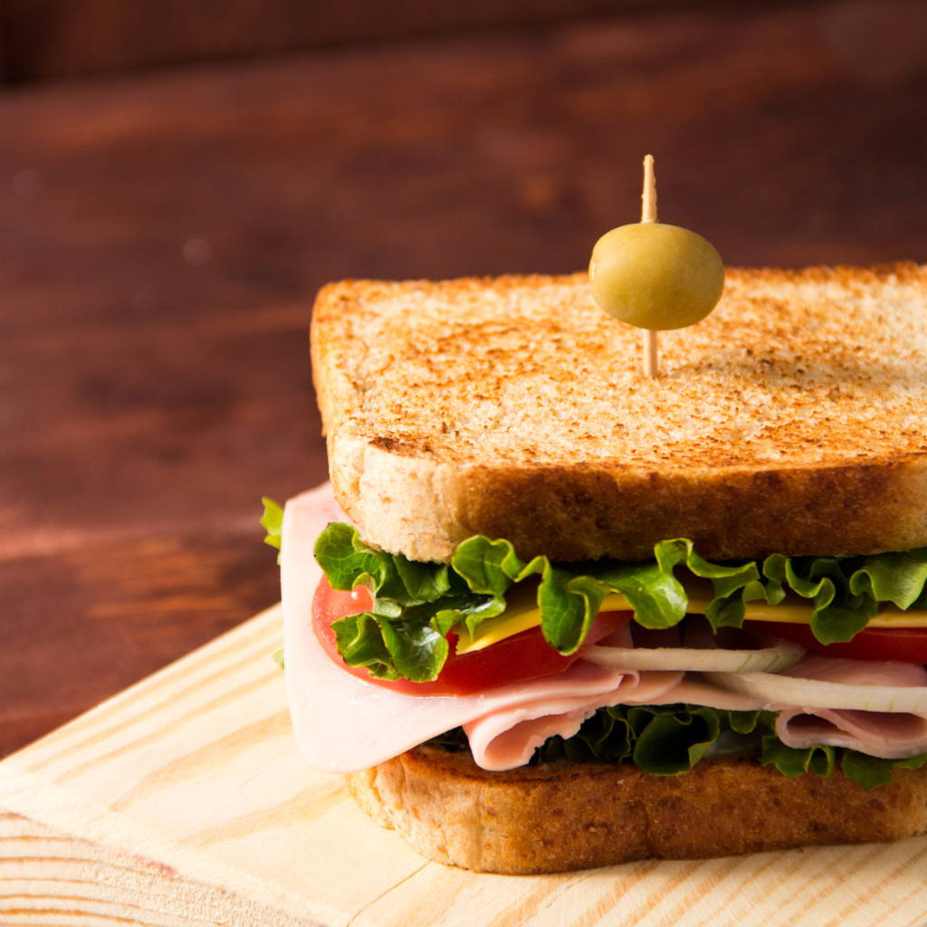 Гамбургер с ветчиной, помидорами, листьями салата и сыром