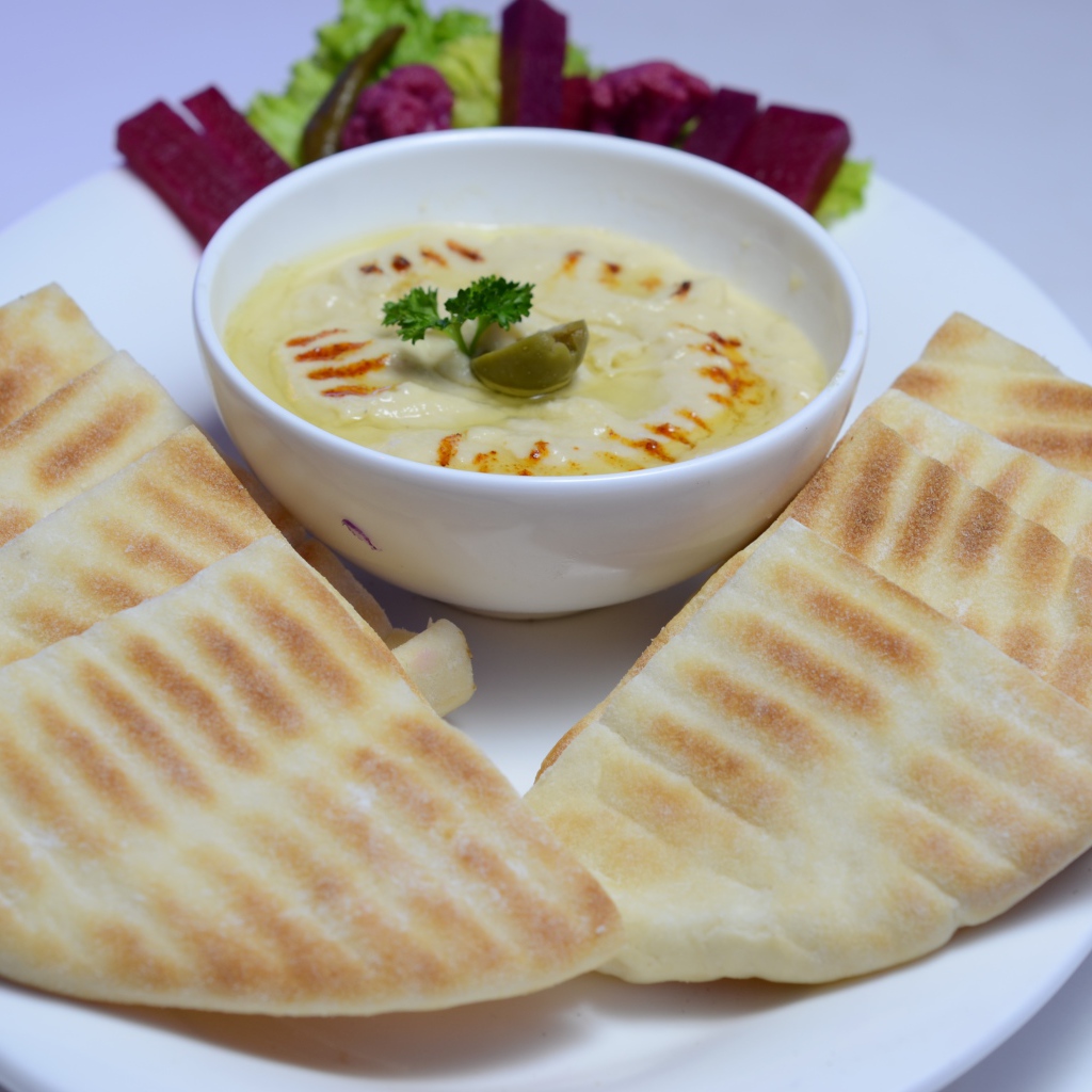 Хумус в белой тарелке с лавашом