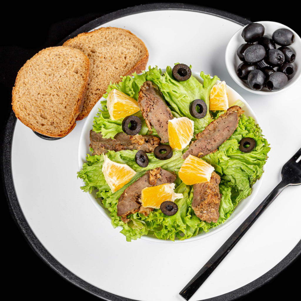 Листья салата с мясом на столе с хлебом