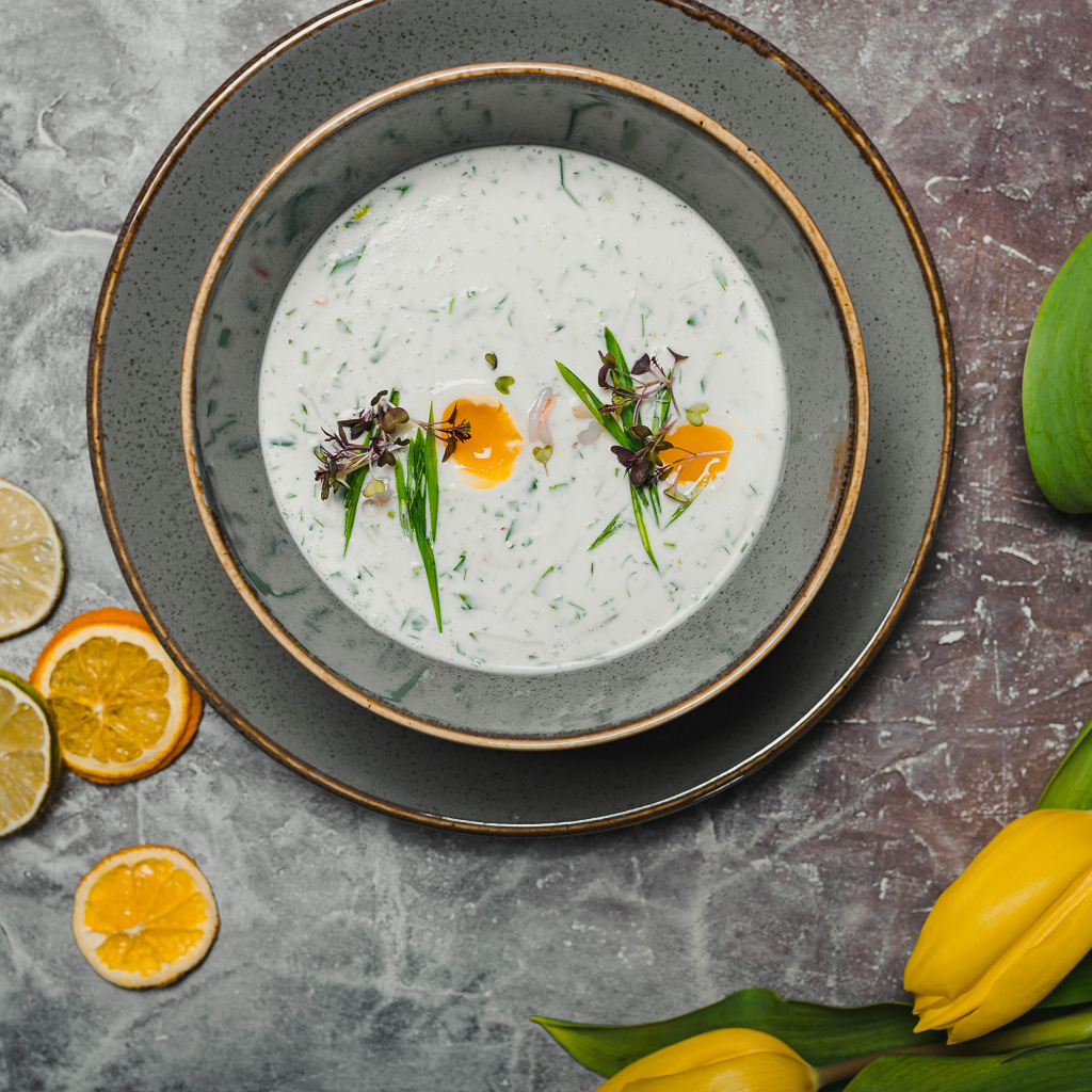 Окрошка на столе с лимонами и тюльпаном