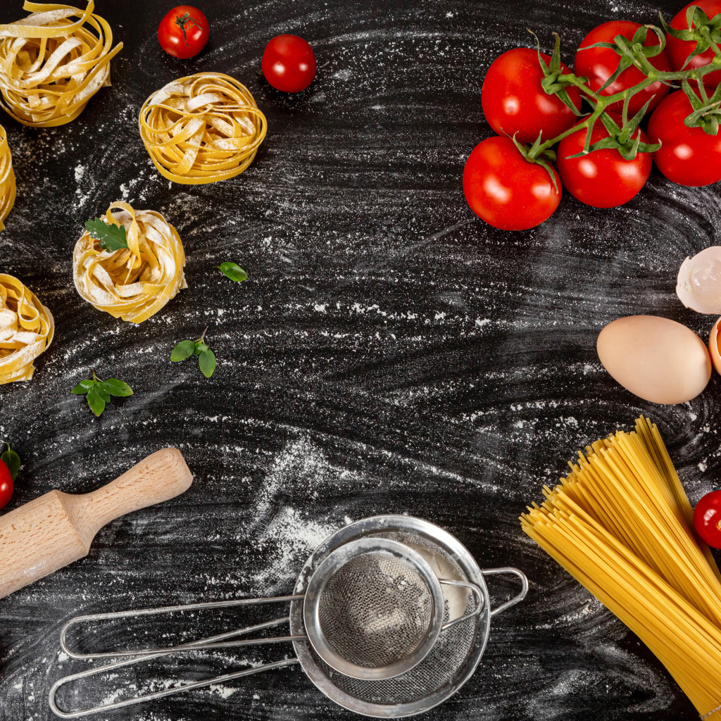 Паста с помидорами и яйцами на черном столе 
