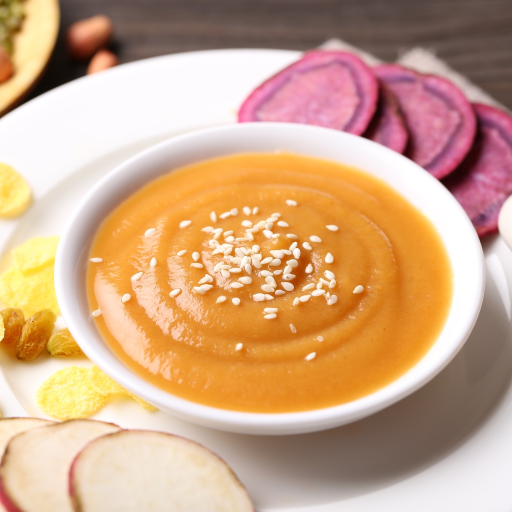 Гороховое пюре в белой тарелке с овощами