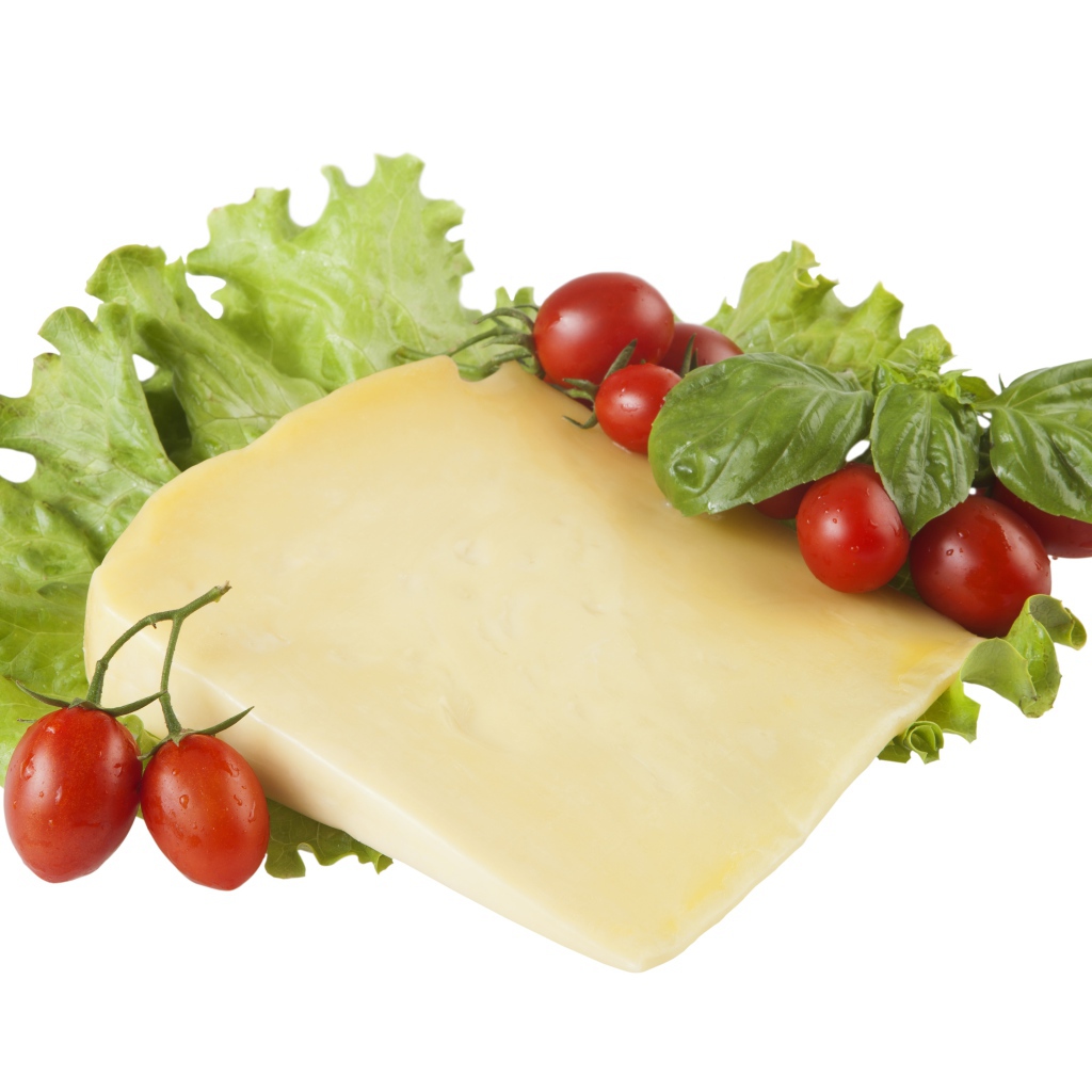 Кусок сыра с помидорами и листьями салата на белом фоне