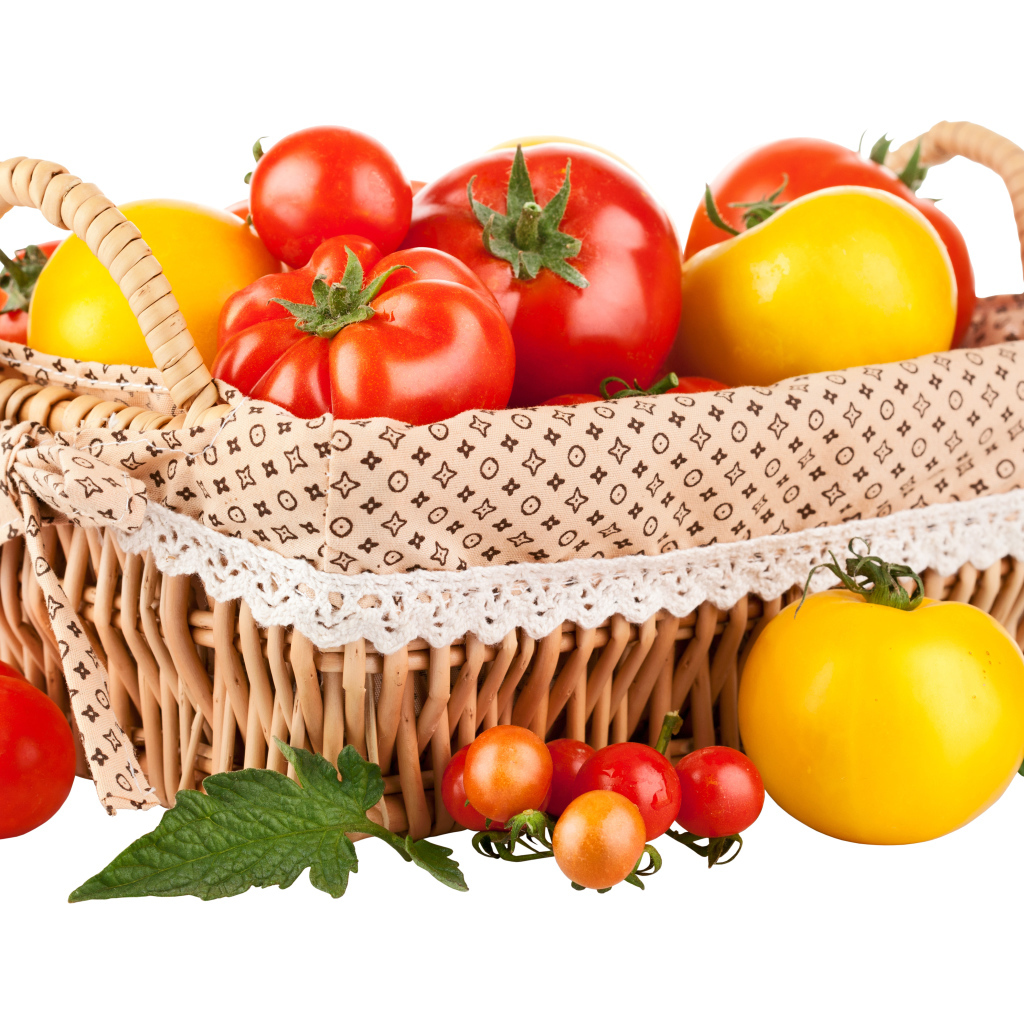 Красные и желтые помидоры в корзине на белом фоне