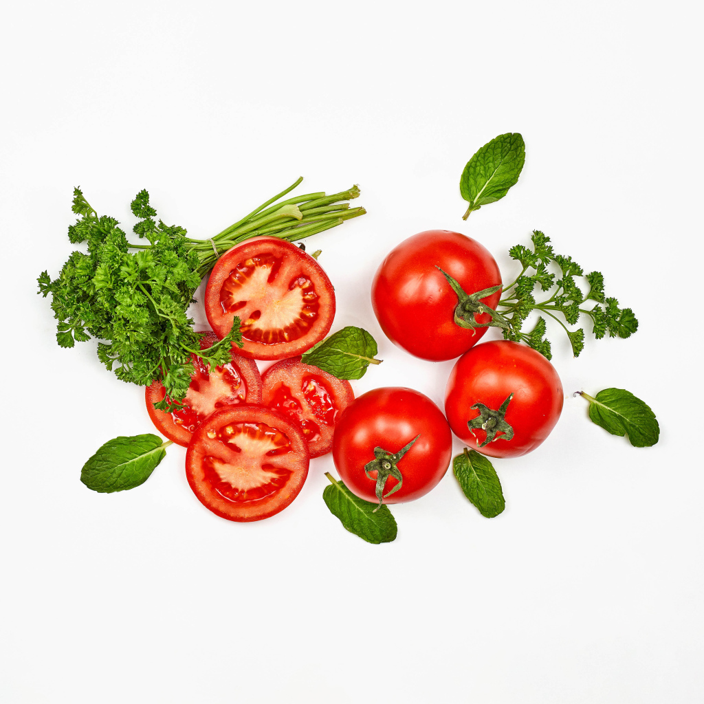 Красные помидоры с петрушкой на белом фоне