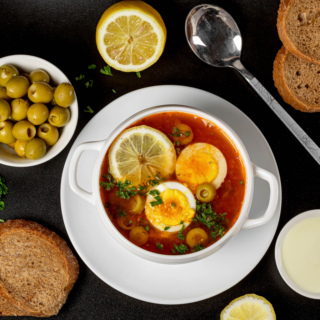 Солянка на столе  с хлебом и оливками 