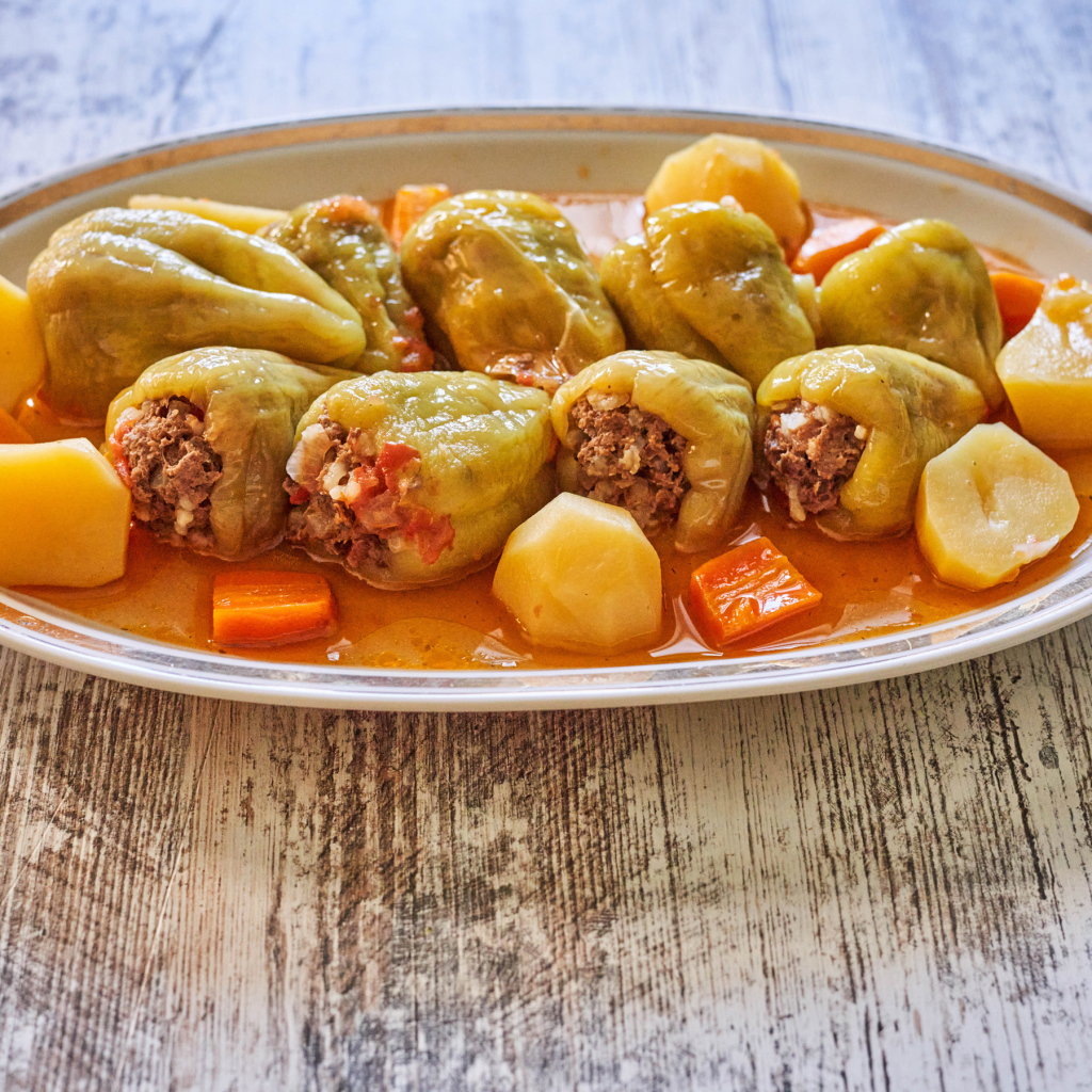 Фаршированный перец на тарелке с картофелем