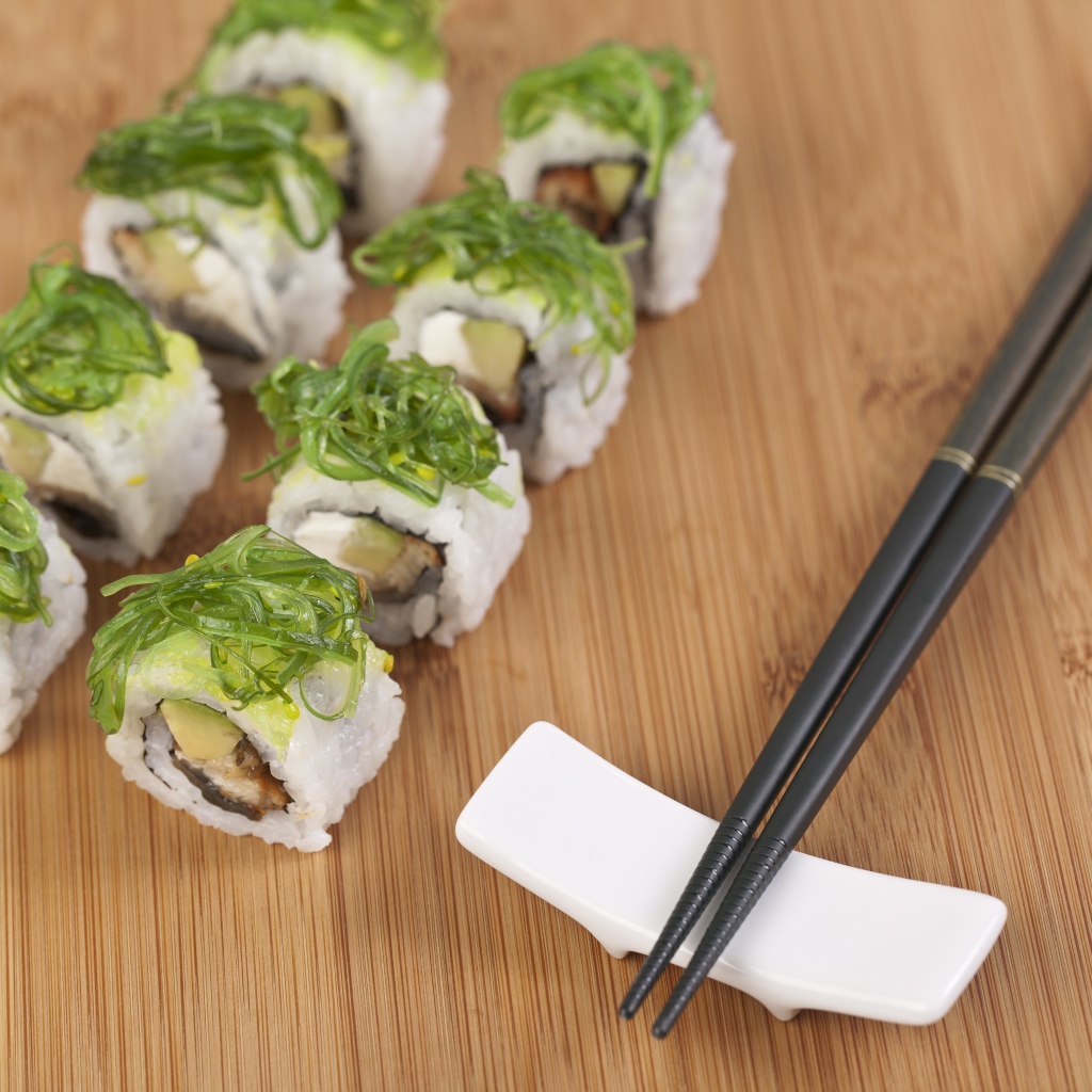 Суши с черными палочками на столе