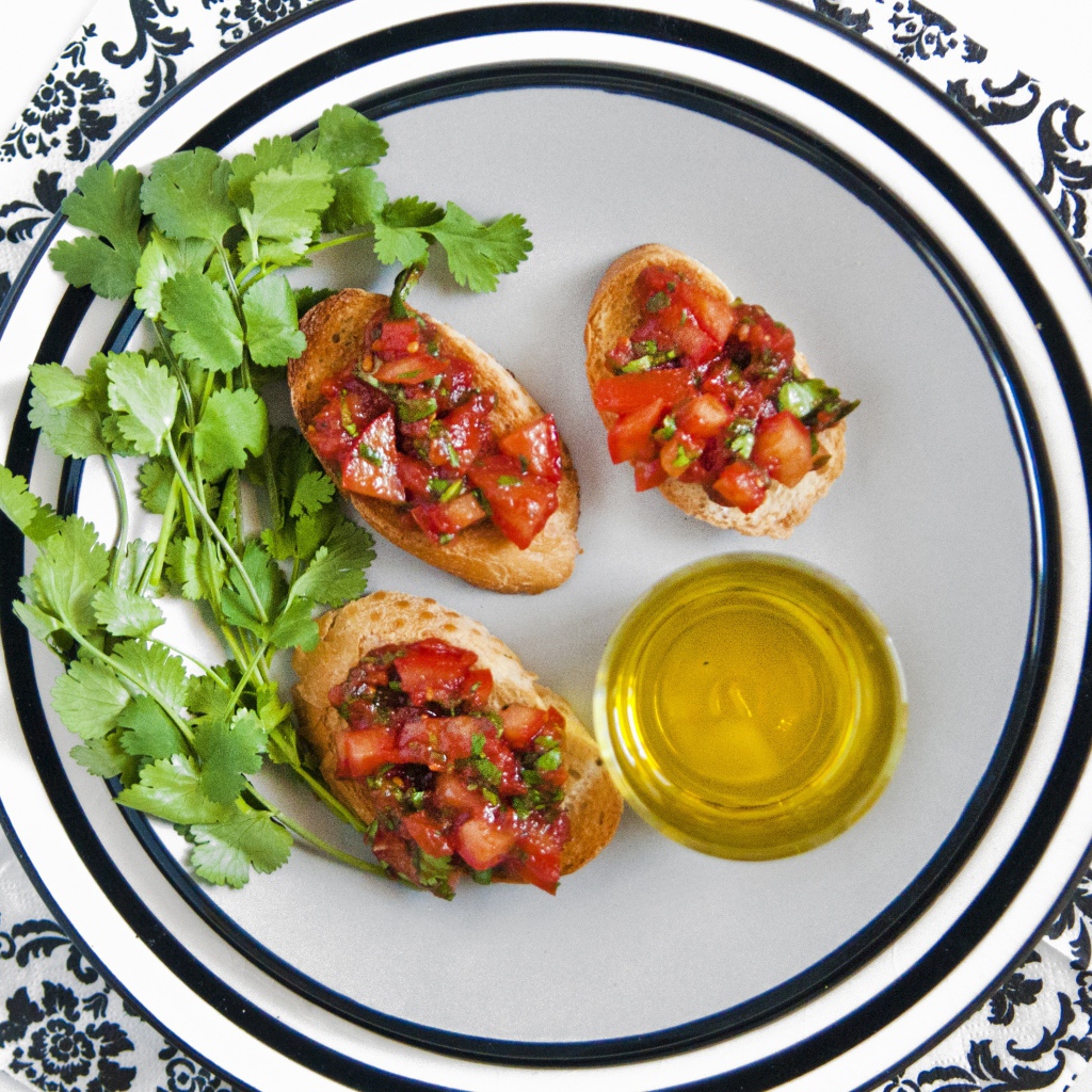 Бутерброды с помидорами на тарелке с петрушкой и маслом