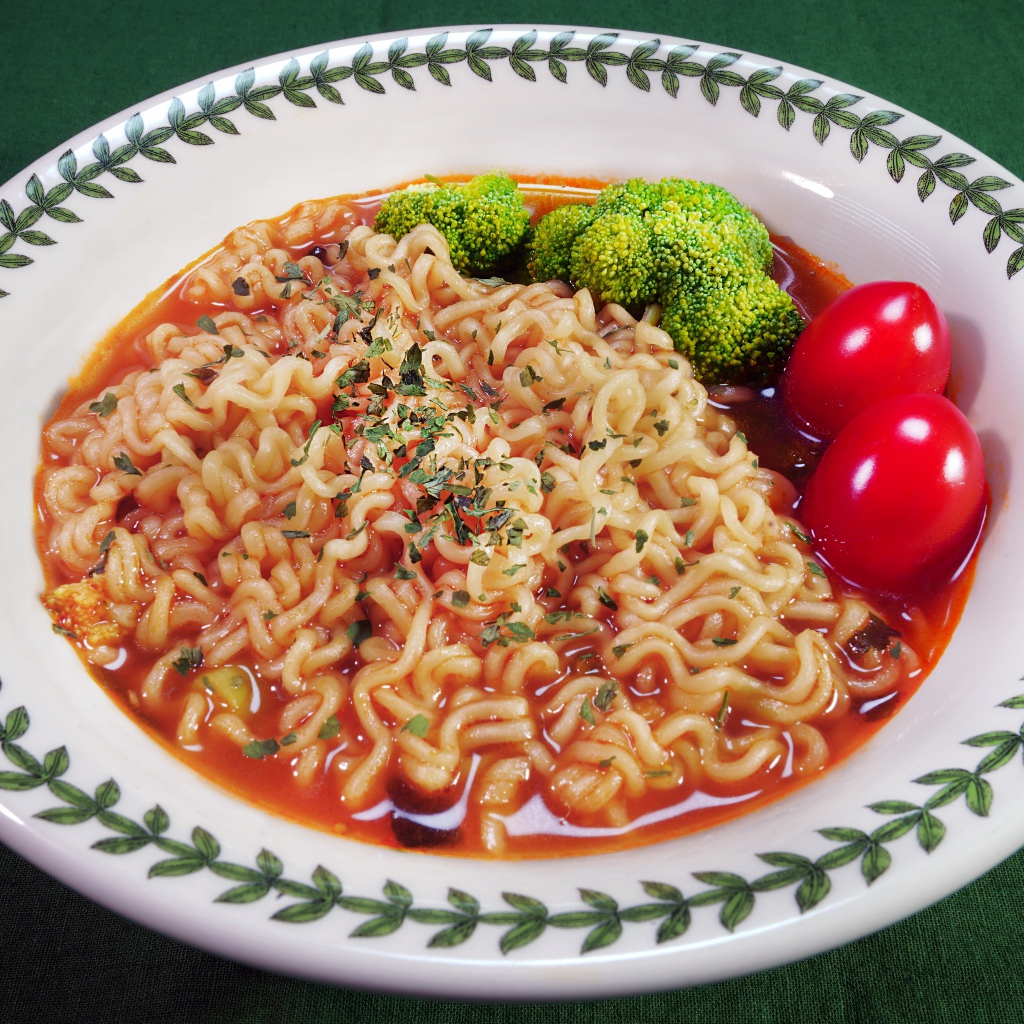 Вермишель с соусом в тарелке с помидорами