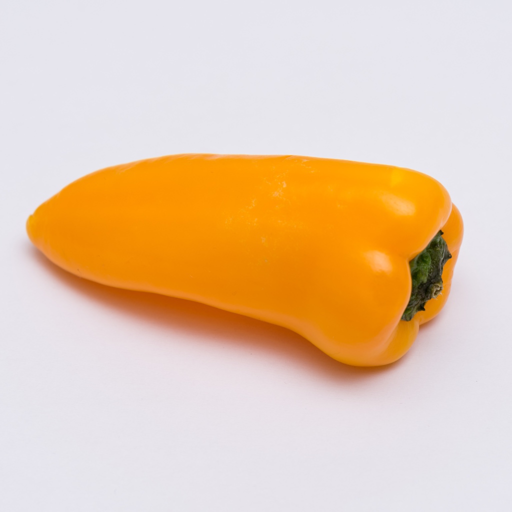 Желтый болгарский перец на сером фоне