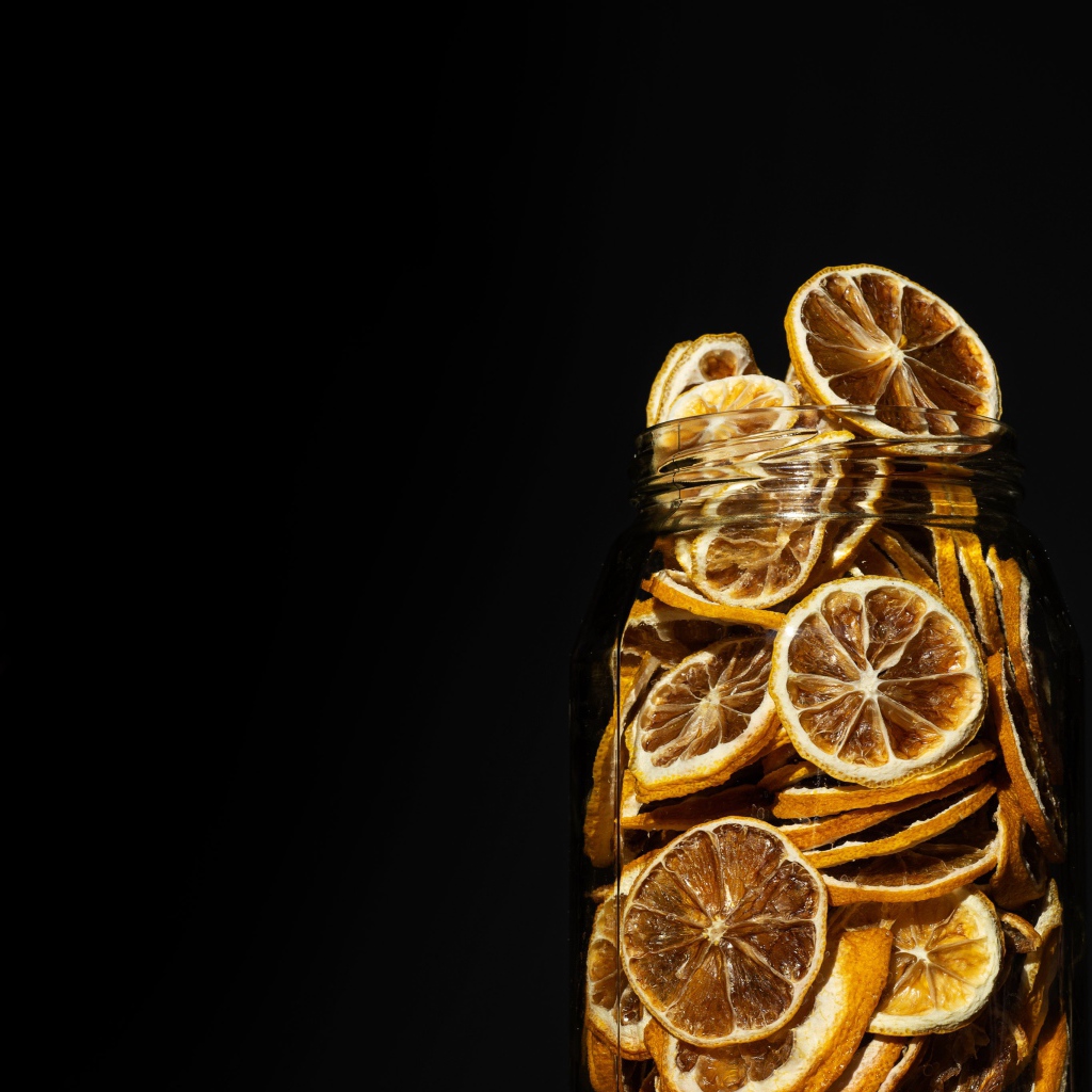Сушеные лимоны в банке на черном фоне