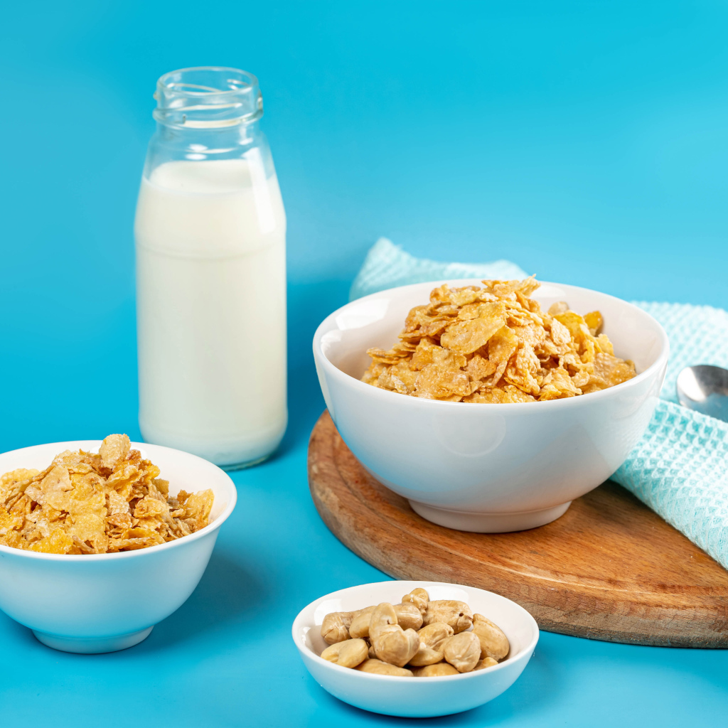Хлопья на столе с орехами и молоком на голубом фоне