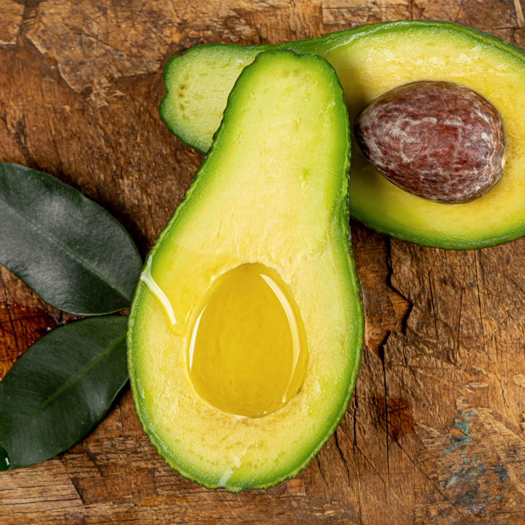 Зеленое авокадо на деревянном столе
