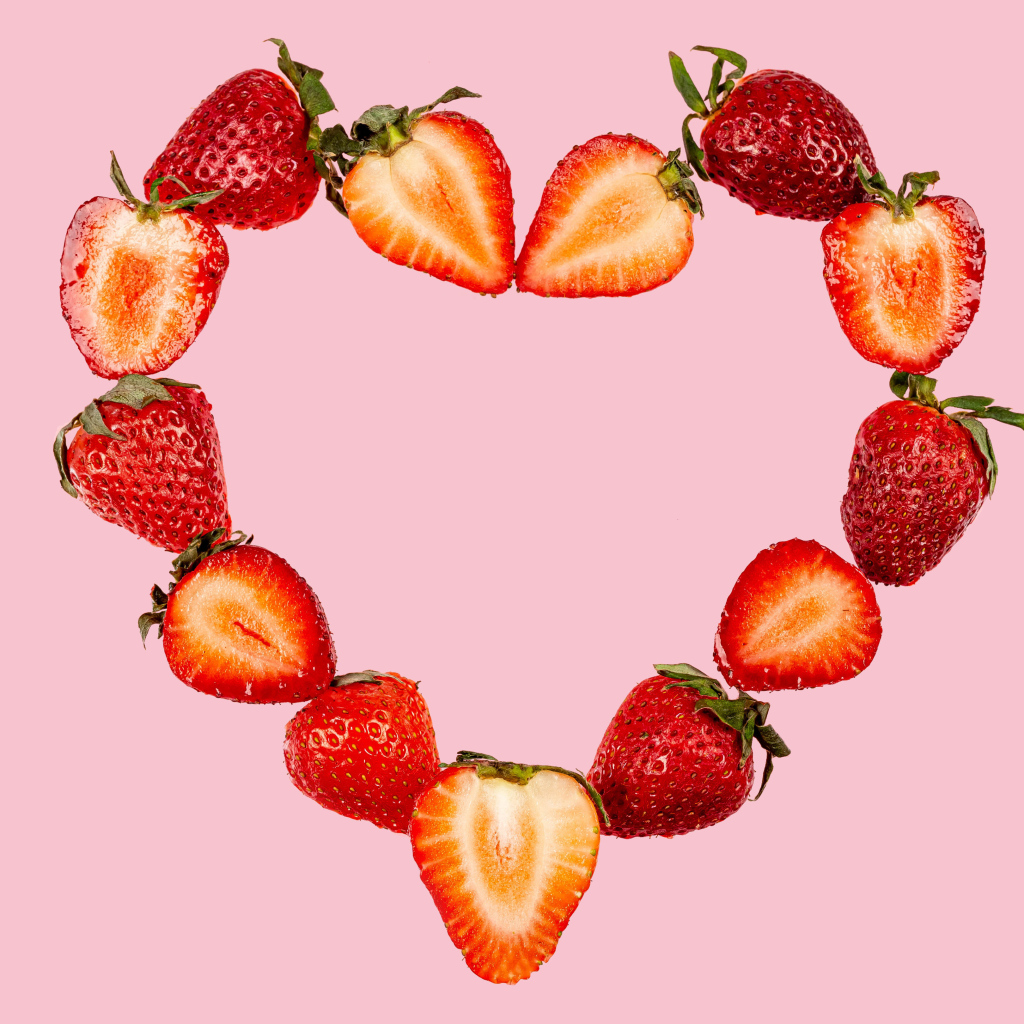 Сердце из клубники на розовом фоне 