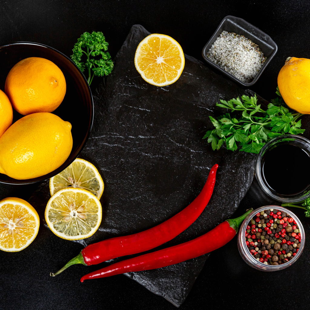 Лимоны на столе с красным перцем, петрушкой  и специями