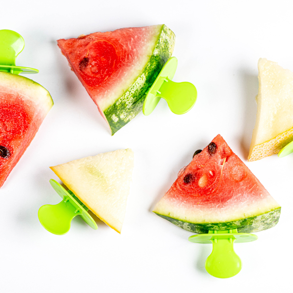 Кусочки арбуза и дыни на палочке на белом фоне 