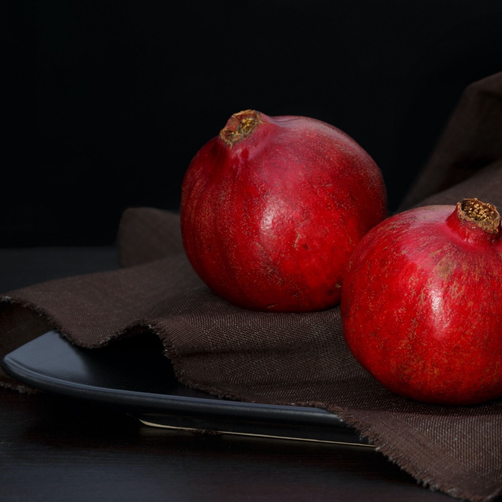 Два красных граната на столе