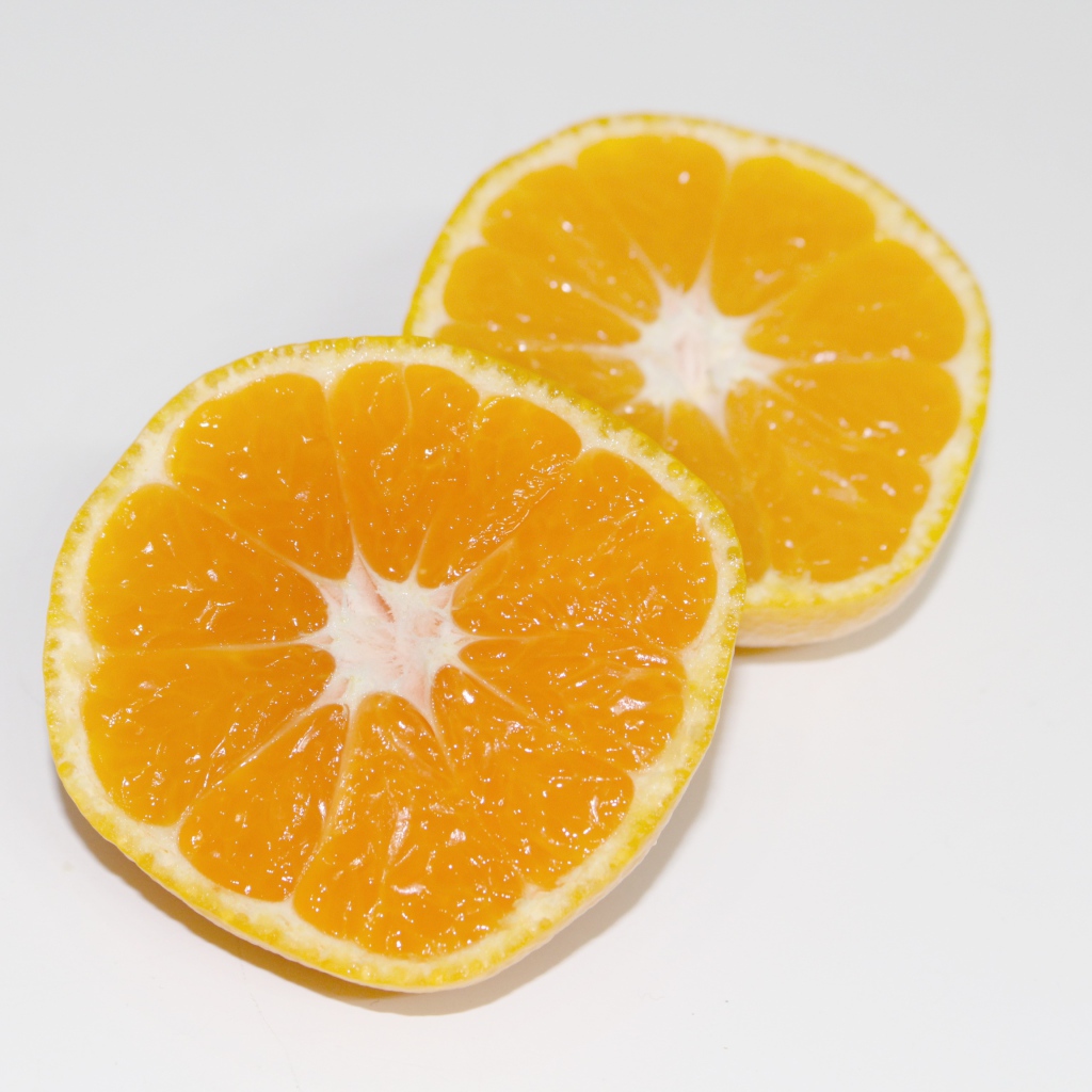 Два кружочка мандарина на сером столе 