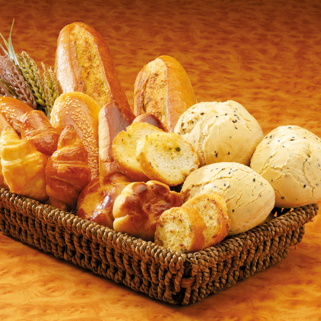 Вкусная свежая выпечка в корзине на столе 