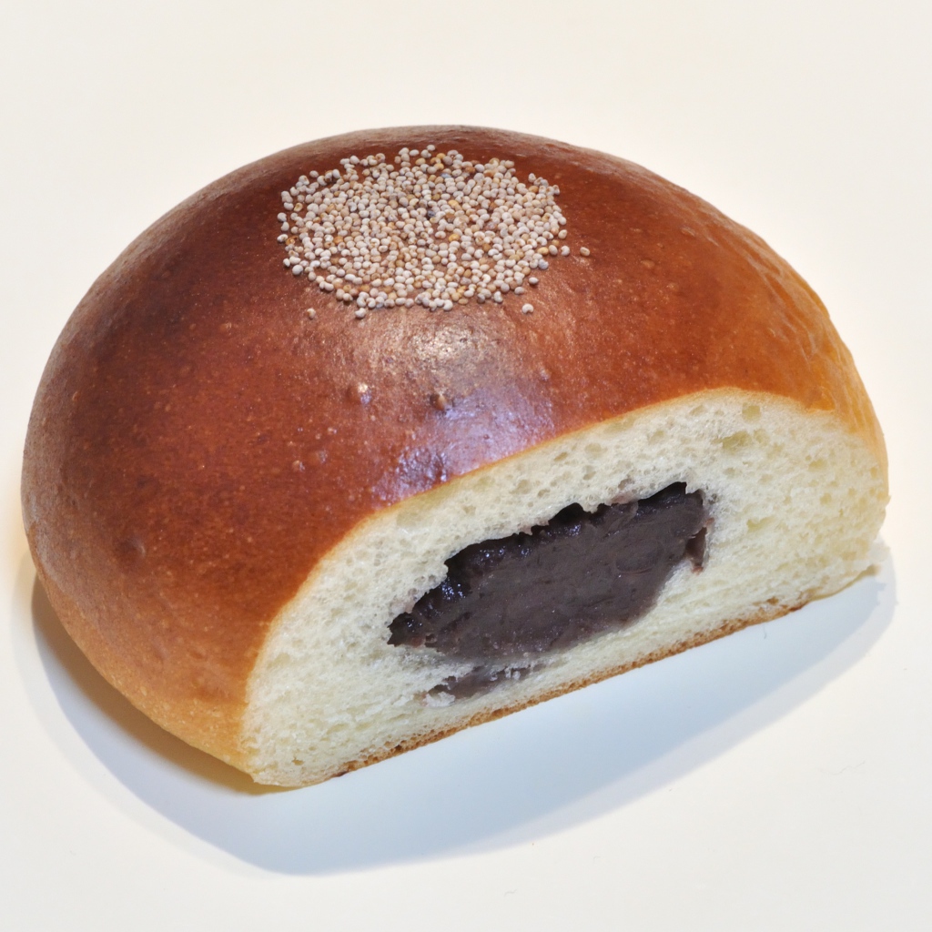 Свежая румяная булочка с вареньем на белом фоне