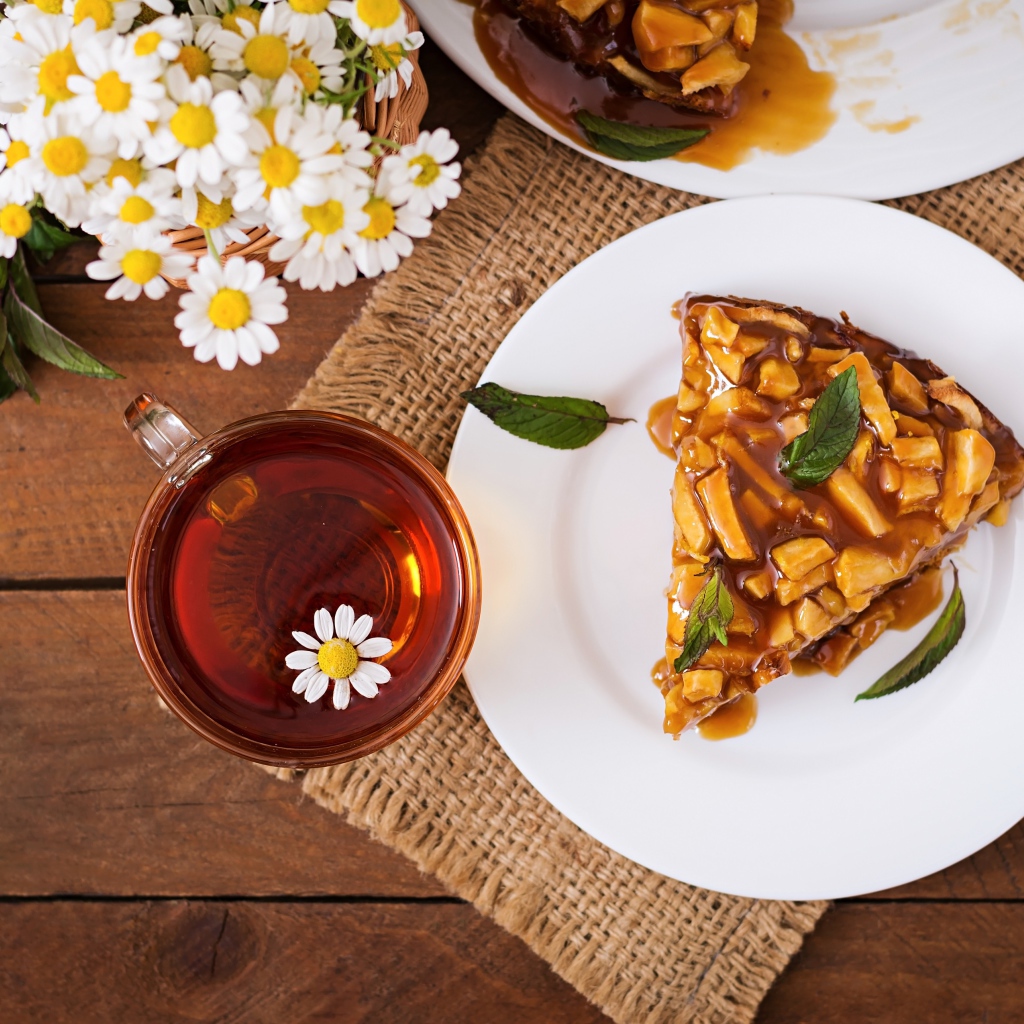 Кружка ромашкового чая на столе с куском пирога