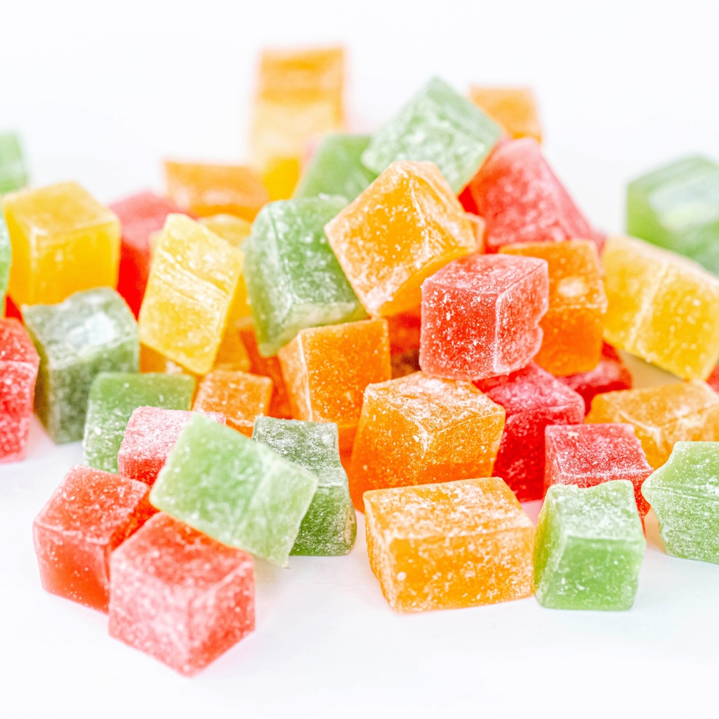 Аппетитный разноцветный мармелад в сахаре на белом фоне 