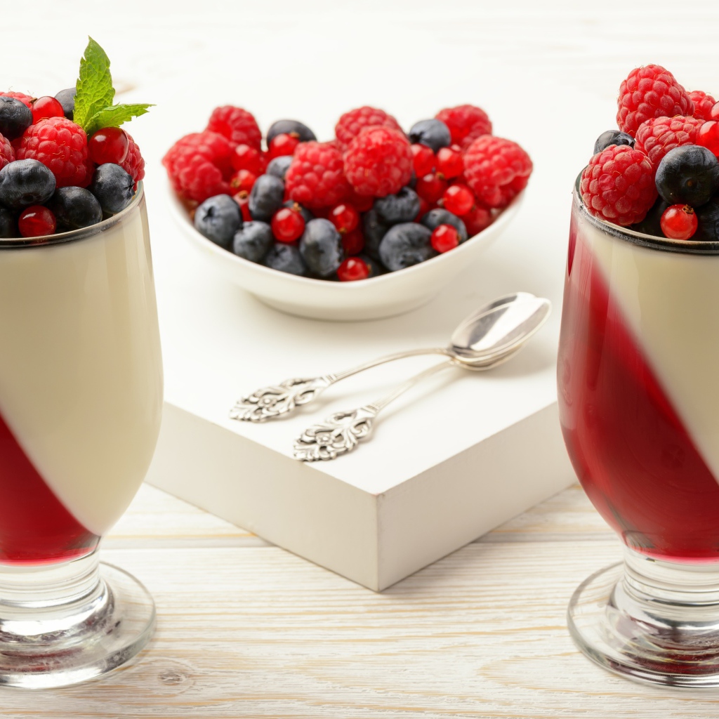 Двухцветный десерт с ягодами на столе 